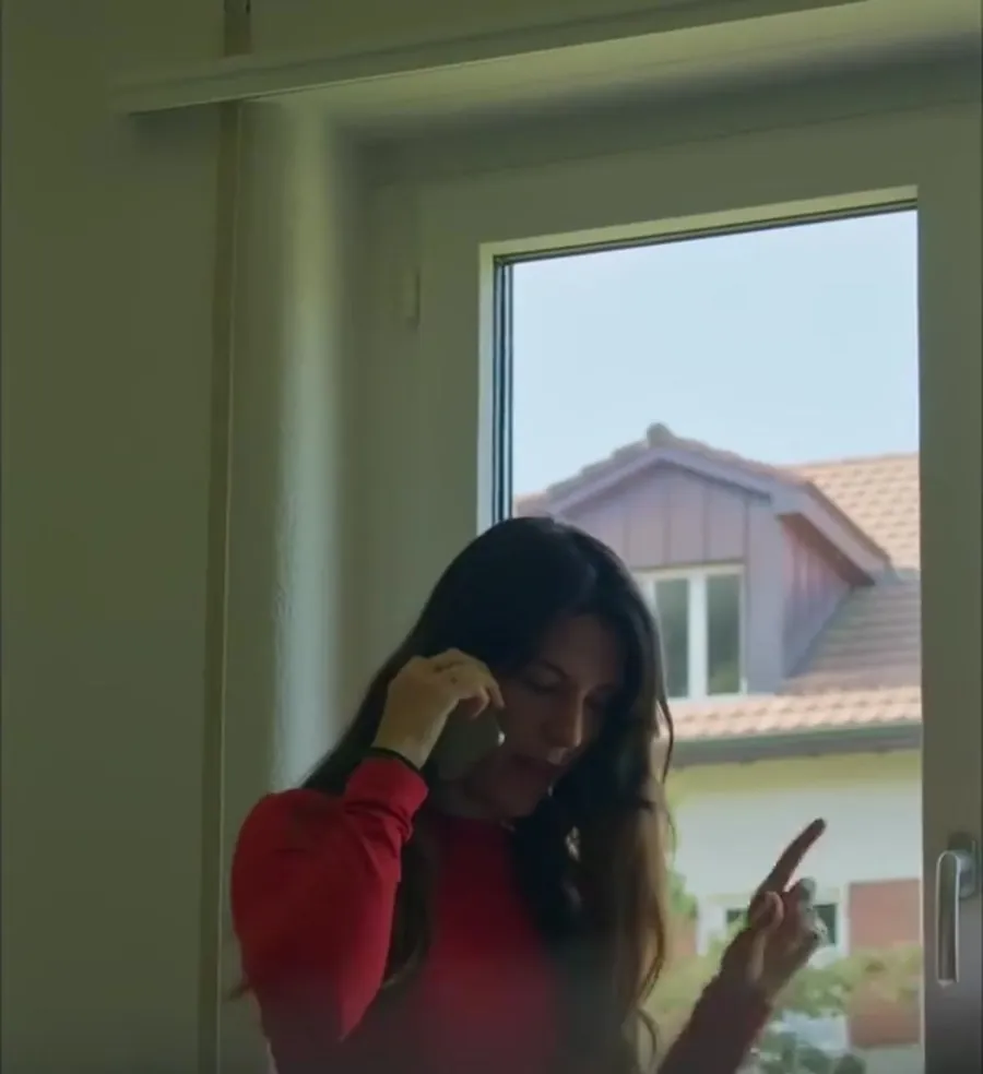L'Anna parlant per telèfon al costat de la finestra
