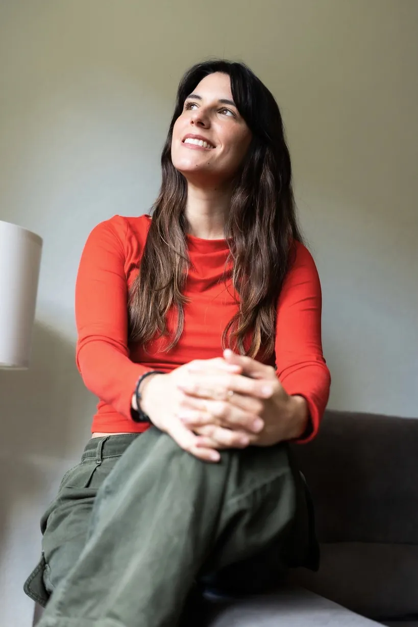 L'Anna somrient, asseguda amb les mans entrellaçades